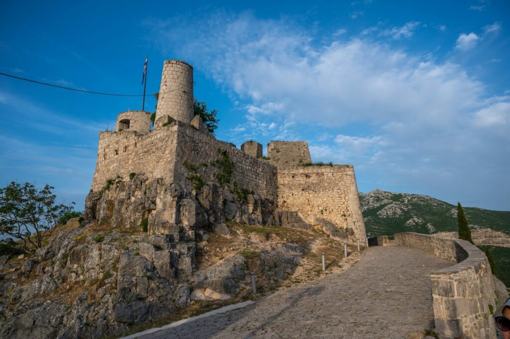 Klis Fortress on a rocky outcrop above Split, ancient stone walls against a Dalmatian mountain skyline