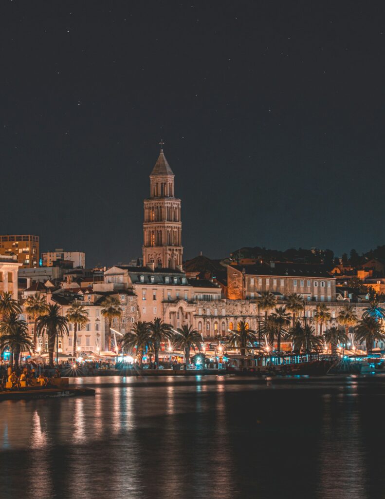 Split's Riva waterfront and the lit bell tower of St. Domnius Cathedral at night